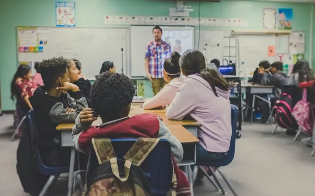 Des enfants en classe face à leur enseignant : enseignement et éducation en français au Canada