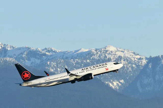 Un avion d'Air Canada décolle devant les montagnes enneigées : le permis de travail Mobilité francophone