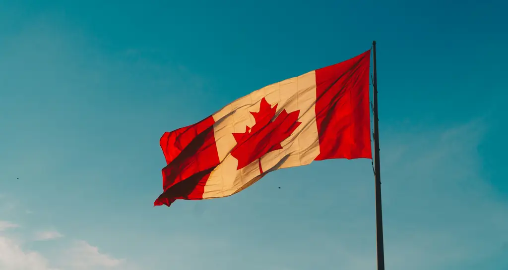 Le drapeau du Canada flottant dans un ciel bleu, symbole de l’immigration fédérale hors Québec