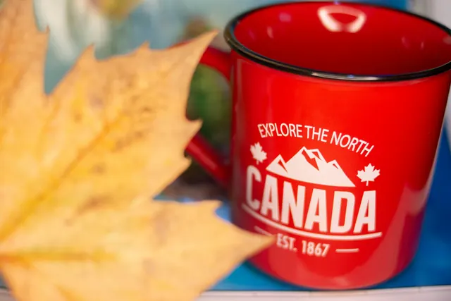 Une tasse rouge « Canada » près d’une feuille d’érable : les premières semaines dans le Nord canadien